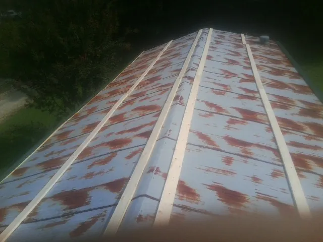 Rusted metal roof panels with new wood purlins before replacement — Storm Damage Roof Repair in Laurinburg by Roofing Brothers