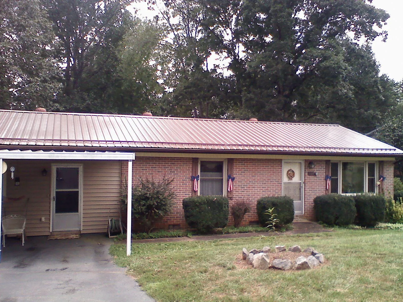 Bronze metal roof and carport on a brick ranch home — Roof Repair work by our crew in Laurinburg