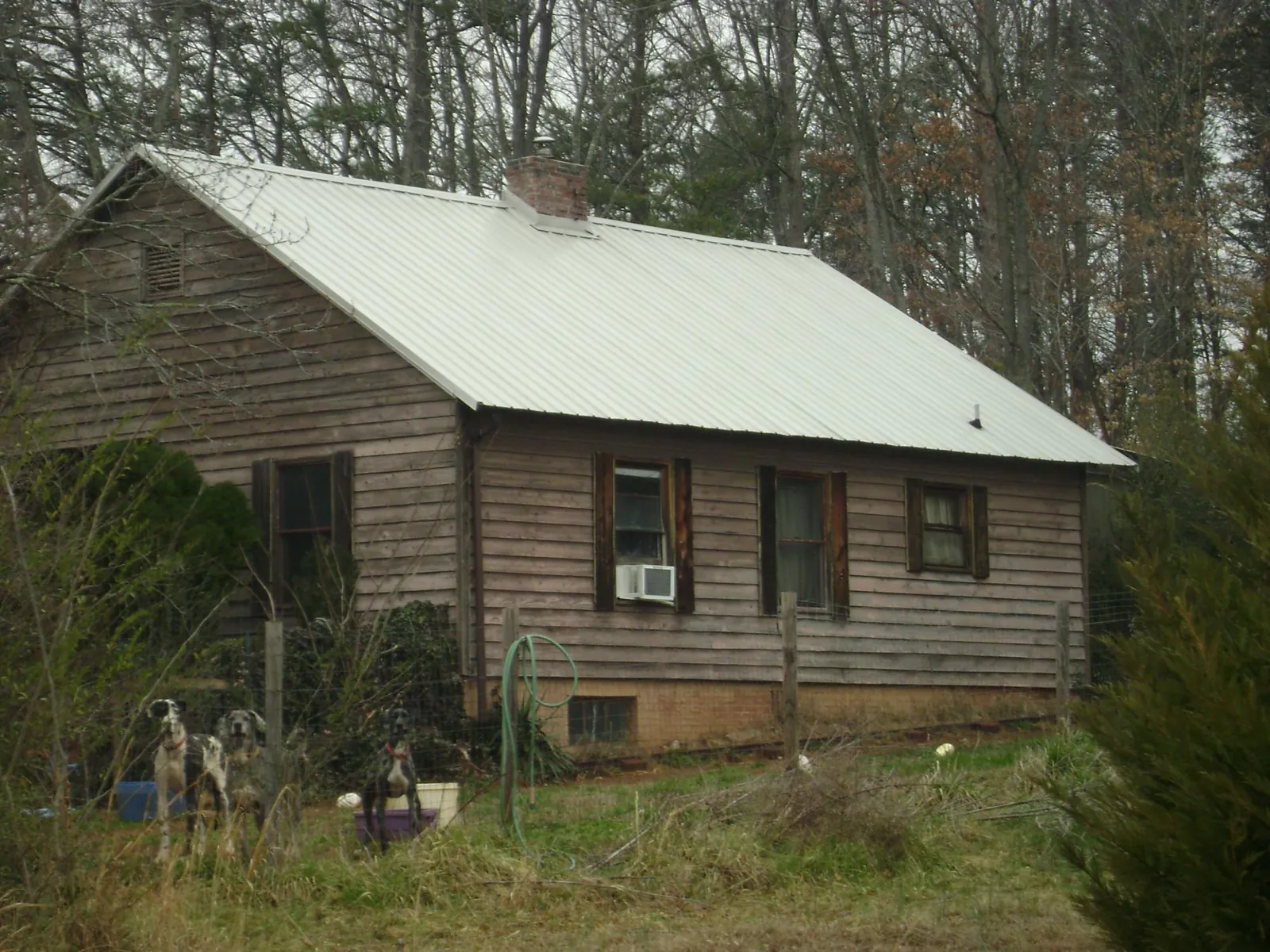 White metal roof on an old wood sided farmhouse, from a Asphalt Shingle Roof Repair job in Laurinburg